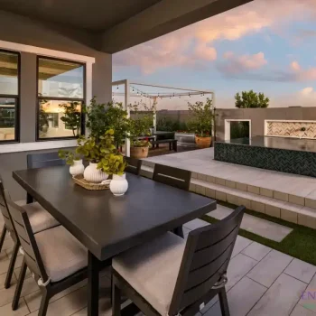 Custom backyard design with outdoor dining area and string lights.