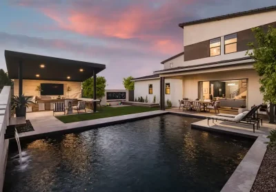 Backyard design with artificial turf, angled shade structure and metal planters.