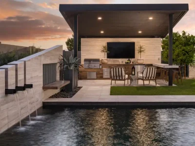 Backyard design with angled shade structure with recessed lighting and an outdoor TV.