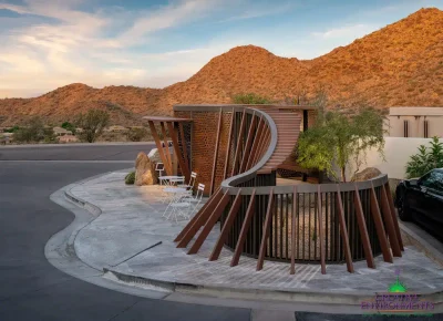 Custom community entrance with metal statement piece, roundabout driveway and multiple seating areas.