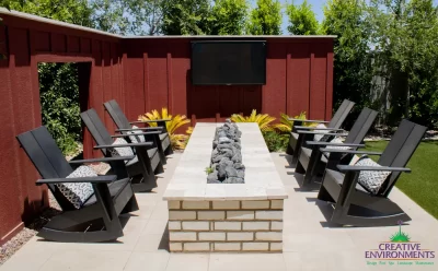 Custom backyard design with outdoor TV, linear fire pit and outdoor entertainment area.