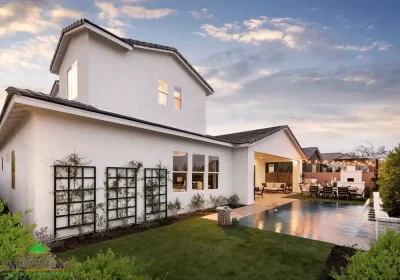 Custom backyard design with metal trellis, zero-edge pool and multiple seating areas.