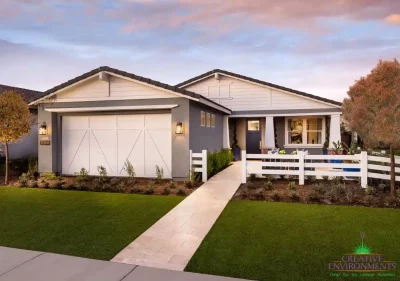 Custom front yard design with organized planting, artificial turf and natural stone tile pathway.