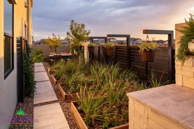 Custom side yard design with metal trellis, hanging plants and herb garden.