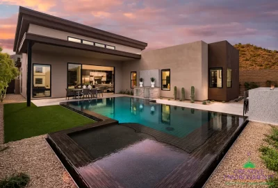 Custom backyard design with zero-edge pool, baja step and outdoor bar seating.