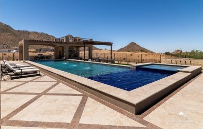 Custom backyard design with resort-style pool, patterned decking and two-story shade structure.