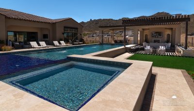 Custom backyard design with raised blue spa, baja shelf and resort-style pool.