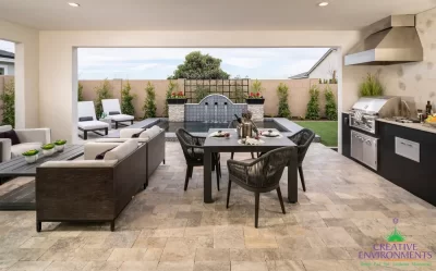 Custom backyard design with topiaries, outdoor kitchen and multiple seating areas.