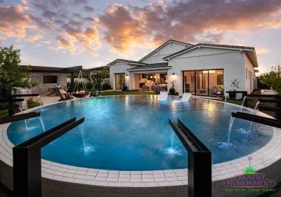 Backyard design with cantilevered wok fire pit, metal scupper water feature into blue pool and baja step.