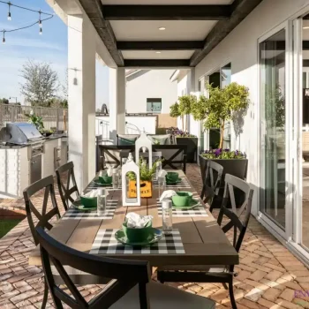 Custom backyard design with multiple seating areas, metal planters and string lights.