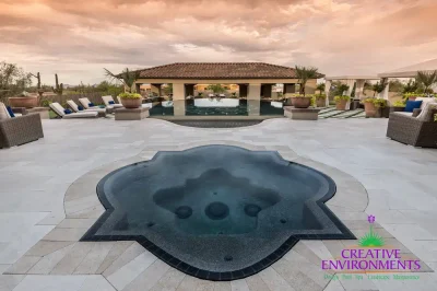 Custom backyard design with artificial turf pattern, unique-shaped spa and large planters.