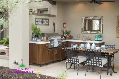 Custom backyard design with outdoor kitchen, outdoor dining area and planters.
