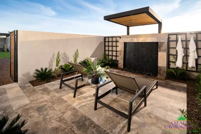 Custom backyard design with cantilevered outdoor shower, black water wall and metal trellises.