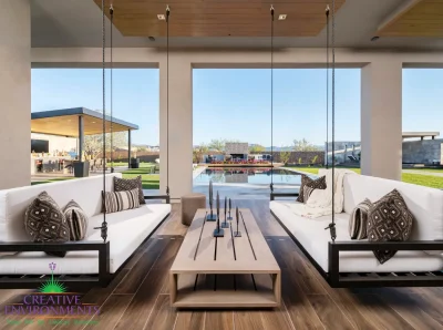 Custom backyard design with hanging seating, angled shade structure and zero-edge pool.