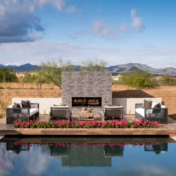 Custom backyard design with fireplace, raised seating area and zero-edge pool.