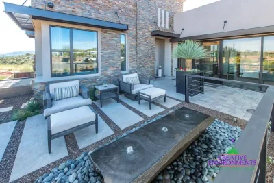 Backyard design with multiple seating areas and metal planters.