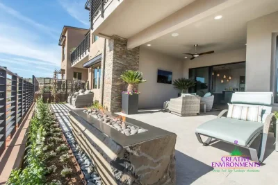 Backyard design with fire table and outdoor fan.