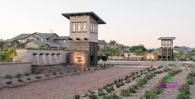 Custom community entrance with cantilevered planters, organized planting and metal scupper water feature.