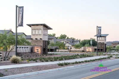 Custom community entrance with cantilevered planters, metal scupper water features and organized planting.