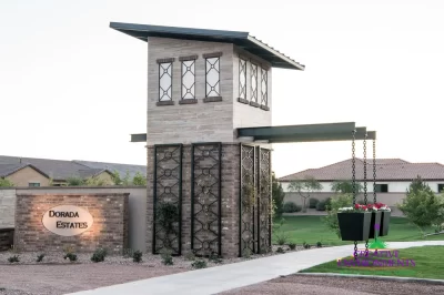 Custom community entrance with entryway sign, metal trellis and real grass.