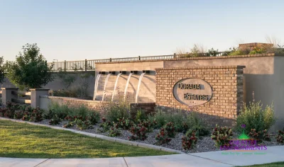 Custom community entrance with entryway sign, metal scupper water feature and organized planting.