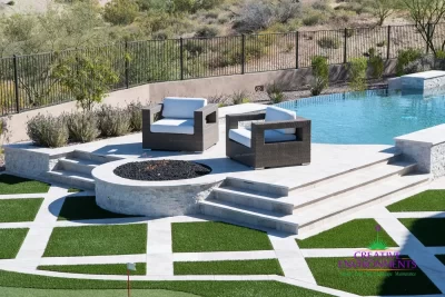 Custom backyard design with metal fencing, circular fire pit and artificial turf pattern.