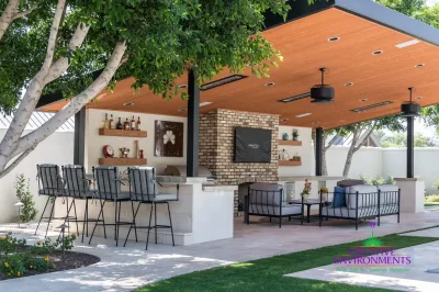 Custom backyard design with angled shade structure, multiple seating areas and real grass.