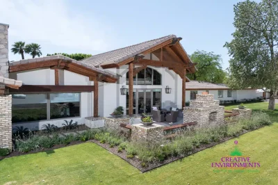 Custom backyard design with focal point brick fireplace, wok planters and multiple seating areas.