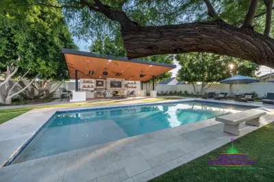 Custom backyard design with angled shade structure, deco-tile pool and multiple seating areas.