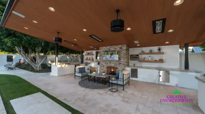 Custom backyard design with outdoor shelving, recessed lighting and outdoor kitchen.