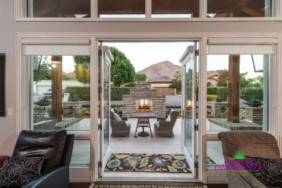 Custom indoor/outdoor design fusion with brick fireplace, multiple seating areas and natural stone pavers.