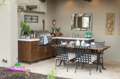 Custom backyard design with outdoor BBQ, outdoor dining area and organized planting.