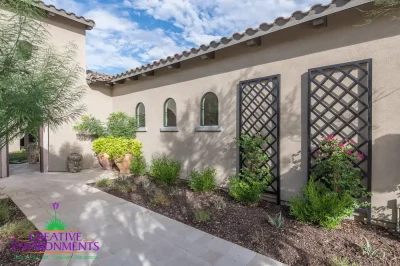 Custom front yard design with metal trellis, large planters and natural stone pavers.