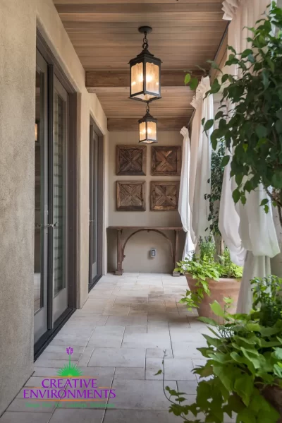 Custom indoor/outdoor design fusion with large planters, privacy curtains and black hanging lights.