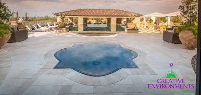 Custom backyard design with unique-shaped spa, large planters and multiple seating areas.
