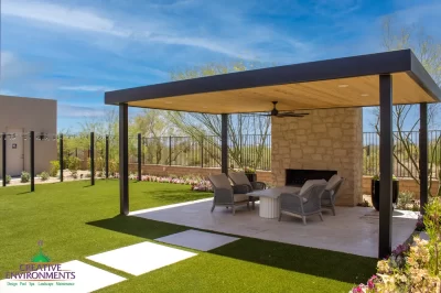 Custom backyard design with metal shade structure, string lights and artificial turf.