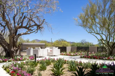 Custom backyard design with metal fencing, outdoor seating area and organized planting.