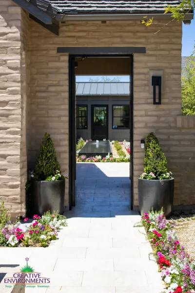 Custom backyard design with entryway door, annuals and large planters.