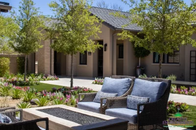 Custom front yard design with trees, fire table and organized planting.
