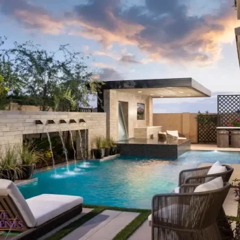 Custom backyard design with cantilevered shade structure and metal scupper water feature into unique-shaped pool.